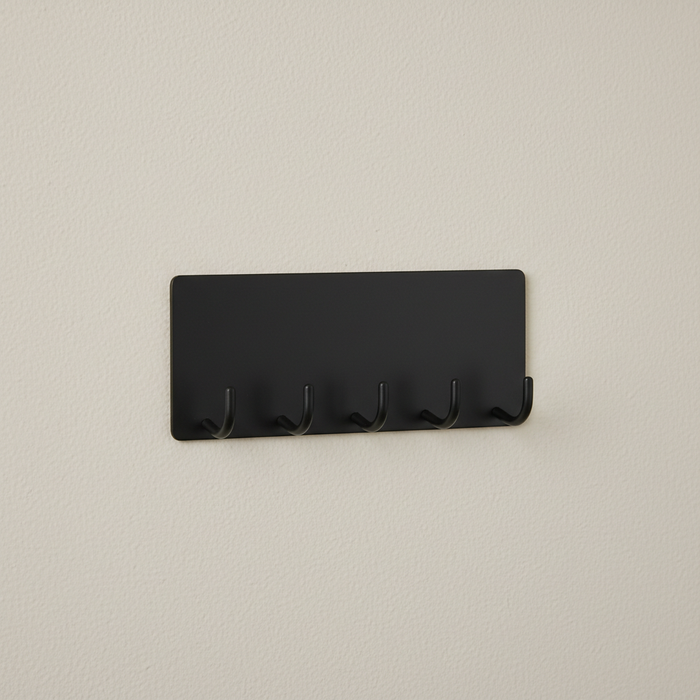 Black wall-mounted metal key holder with five hooks